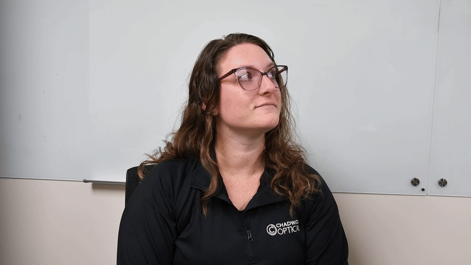 Michelle from Chadwick Optical demonstrates the use of a flipper kit, looking upward thoughtfully during the process.