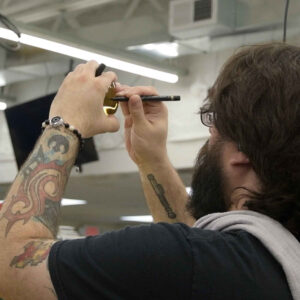 lab-staff-7 Chadwick Optical employee inspects a lens closely, using a marker to mark specific points on the lens.
