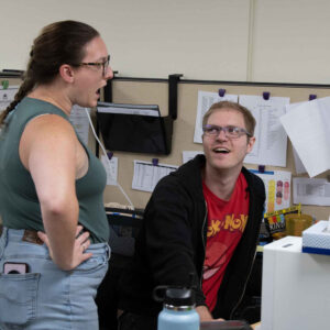 office-staff-2 Michelle and John having an animated conversation at John's workstation in the Chadwick Optical office.