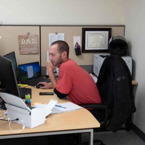 office-staff-3 An employee focusing on tasks at a dual-monitor setup in an office cubicle at Chadwick Optical.